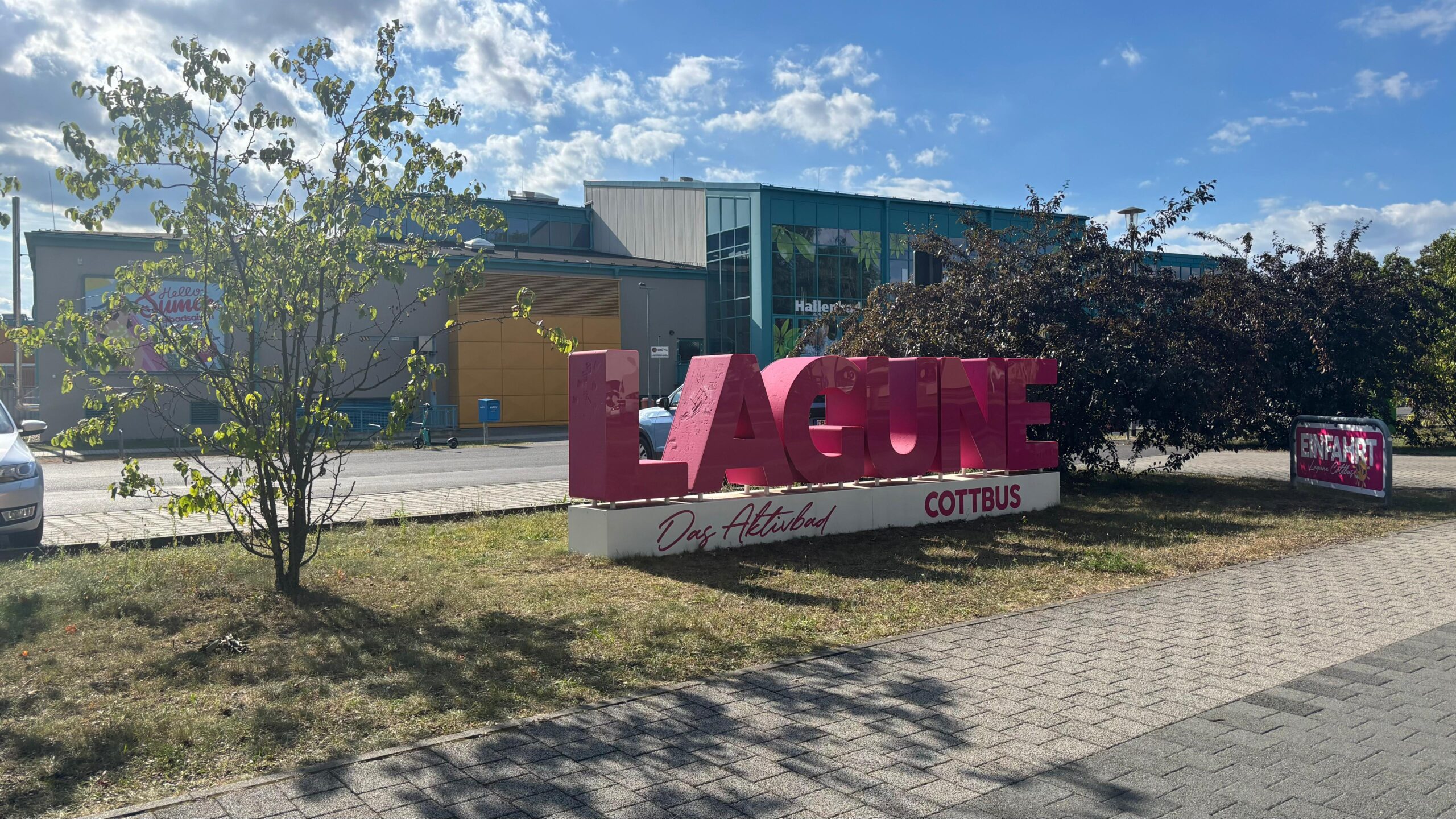 Lagune Cottbus mit dem Lila Schriftzug an einem sonnigem aber bewölktem Tag Schwimmhalle in Cottbus Spaßbad Freizeitbad