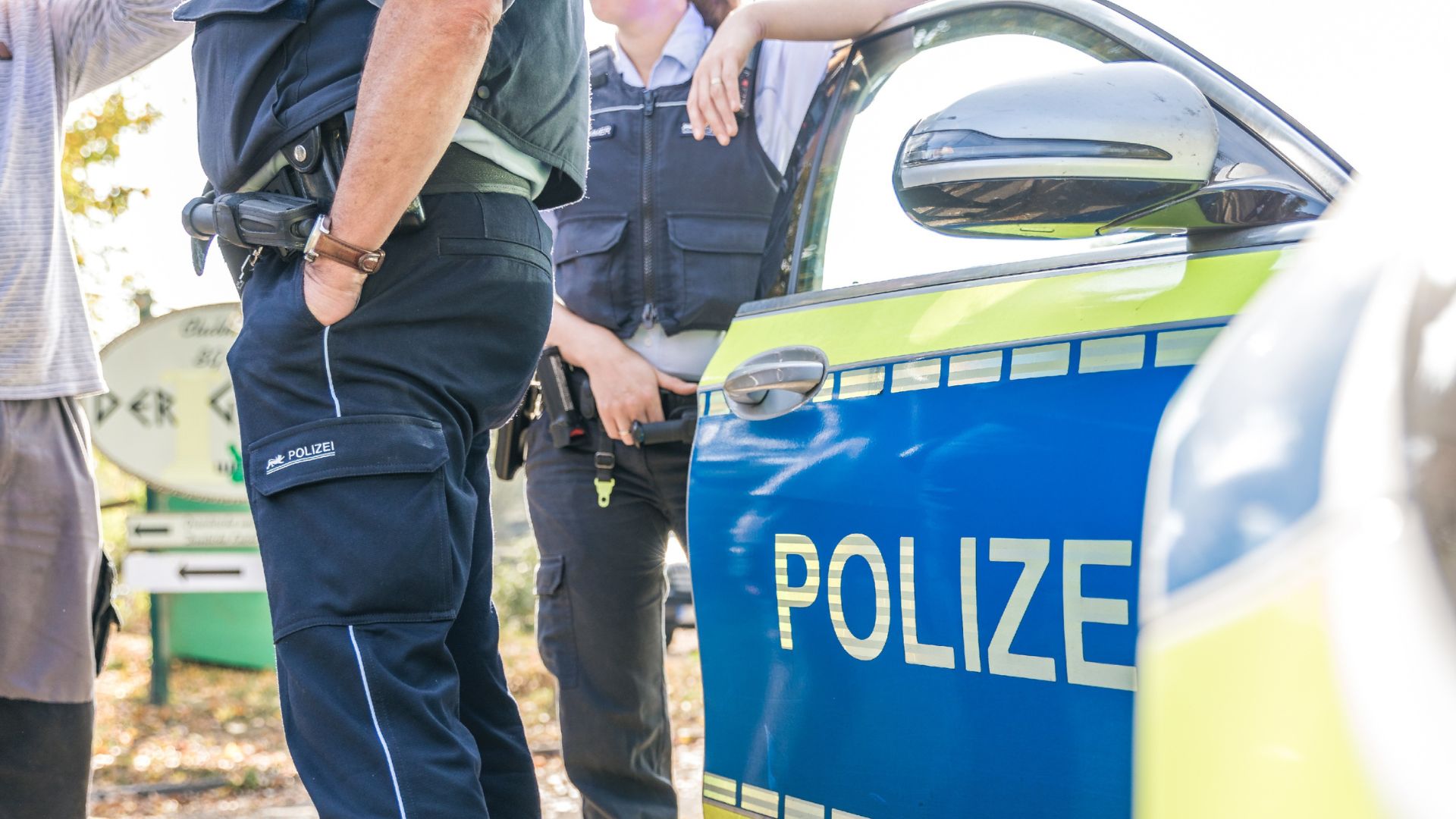 Polizeiauto mit zwei Polizisten stehen vor einem griechischem Restaurant ein einem herbstlichen Tag