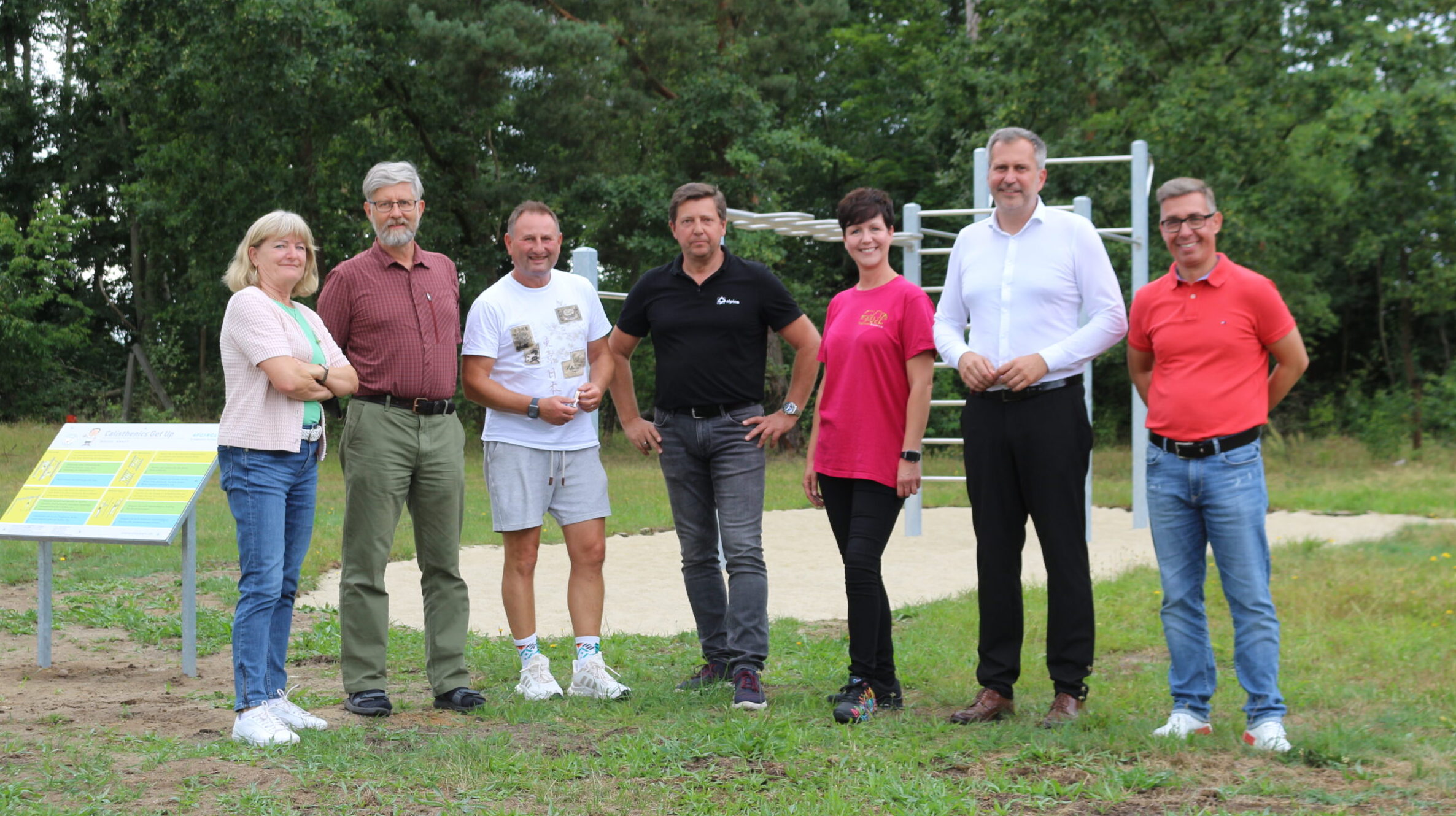 Oberbürgermeister der Stadt Cottbus Tobias Schick und andere stehen vor einem Spielgerät in Cottbus Branitz